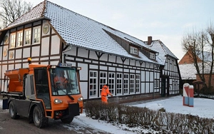 Fahrzeug und Personen beim Winterdienst vorm Standesamt